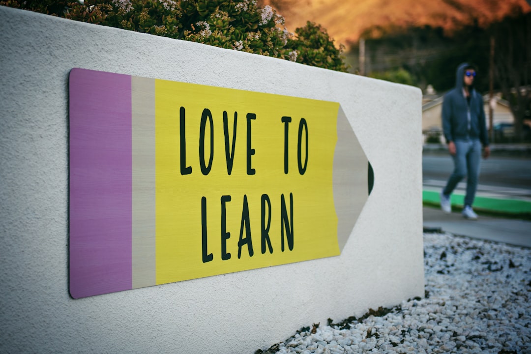 Love to Learn | Instagram: @timmossholder by Free IQ Tests love to learn pencil signage on wall near walking man